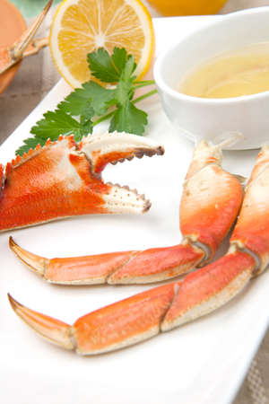 Assorted Dungeness crab legs with butter mustard sauce and fresh lemons.の写真素材
