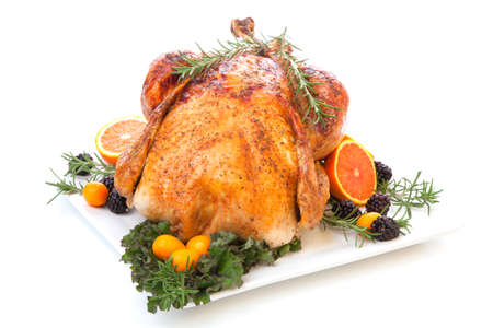 Roasted stuffed turkey garnished with fresh fruits and herbs for holiday dinner.の写真素材
