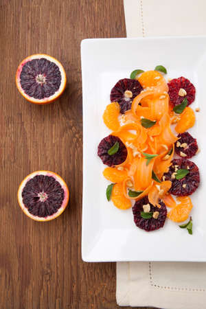 Closeup of a plate of blood oranges, carrots, and tangerines salad with peanut-mint dressing.の写真素材