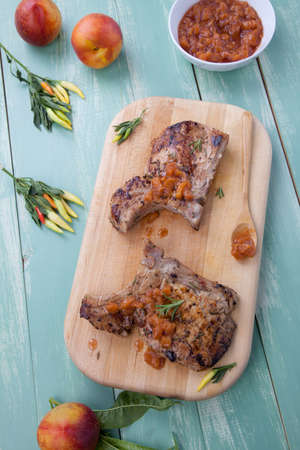Grilled pork chops with nectarine - pepper chutney. Fresh nectarines and hot pepper.の写真素材