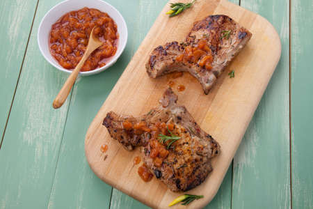 Grilled pork chops with nectarine - pepper chutney. Fresh nectarines and hot pepper.の写真素材