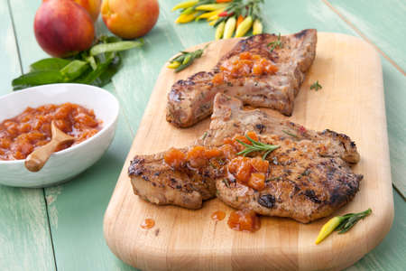 Grilled pork chops with nectarine - pepper chutney. Fresh nectarines and hot pepper.の写真素材