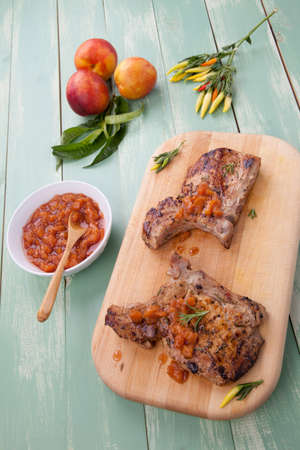 Grilled pork chops with nectarine - pepper chutney. Fresh nectarines and hot pepper.の写真素材