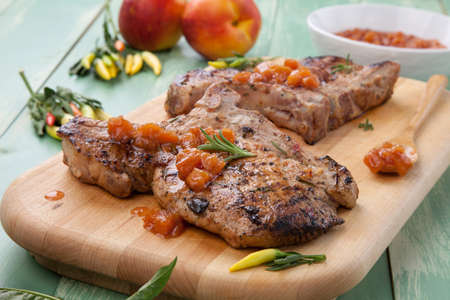 Grilled pork chops with nectarine - pepper chutney. Fresh nectarines and hot pepper.の写真素材