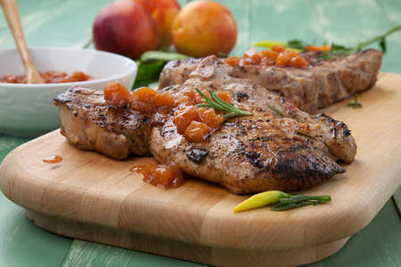 Grilled pork chops with nectarine - pepper chutney. Fresh nectarines and hot pepper.の写真素材