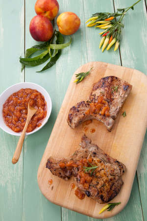Grilled pork chops with nectarine - pepper chutney. Fresh nectarines and hot pepper.の写真素材