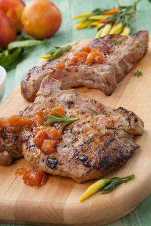 Grilled pork chops with nectarine - pepper chutney. Fresh nectarines and hot pepper.の写真素材