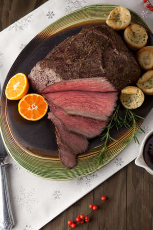 Peppercorn roast beef with herbed Yorkshire puddings and gravy.の写真素材