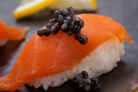 Close up of delicious two pieces Nigiri sushi with fresh salmon and black caviar. Elite food.の写真素材