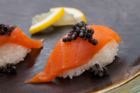 Close up of delicious two pieces Nigiri sushi with fresh salmon and black caviar. Elite food.の写真素材