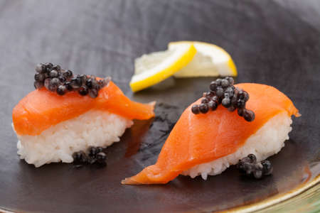 Close up of delicious two pieces Nigiri sushi with fresh salmon and black caviar. Elite food.の写真素材