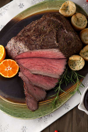 Peppercorn roast beef with herbed Yorkshire puddings and gravy.の写真素材