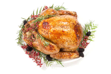 Thanksgiving pepper roasted turkey garnished with blackberry and pink peppercorn on white.の写真素材