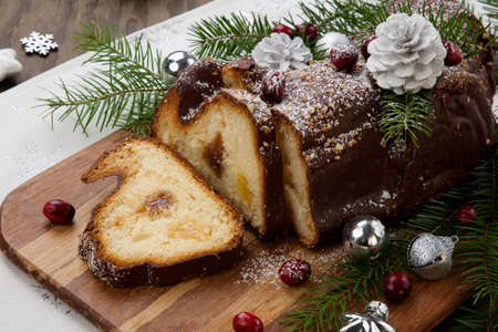 Traditional Christmas chocolate yule log cake with cranberry, Christmas ornamets, and decorations.の写真素材