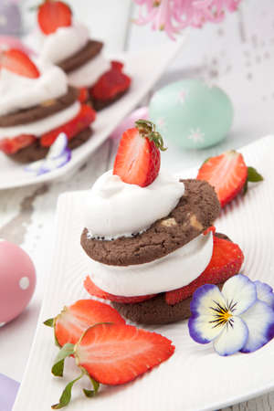 Easter theme deserts - strawberry chocolate Napoleons served with fresh strawberries. Three chocolate shortbread, whipped cream, and slices fresh berries. Easter eggs and flowers.の写真素材
