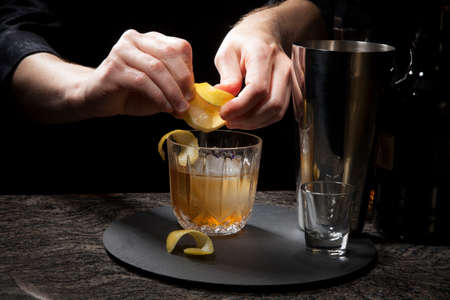 Gin based cocktail - closeup of bartender hands preparing Lavender Collins Cocktail on bar counter.の写真素材