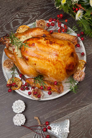 Rustic style roasted Christmas turkey garnished with roasted garlic, lemon, and rosehips.の写真素材