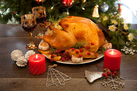 Rustic style roasted Christmas turkey garnished with roasted garlic, lemon, and rosehips.の写真素材