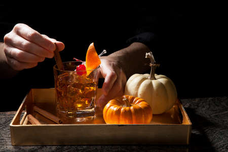 Closeup of bartender hands preparing Old Fashioned Whiskey Cocktail on bar counter.の写真素材