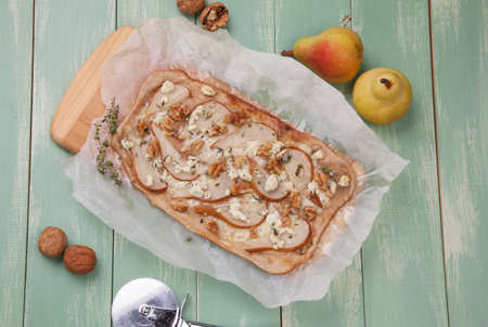 Closeup of homemade pear, goat cheese, and walnut flatbread garnished with fresh thyme.の写真素材