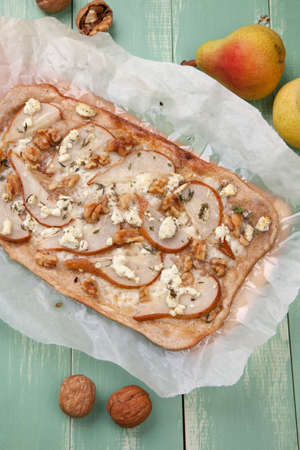 Closeup of homemade pear, goat cheese, and walnut flatbread garnished with fresh thyme.の写真素材