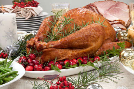 Smoked turkey on a tray garnished with fresh cranberries and herbsの写真素材