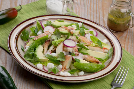 Fusion of Mexican cuisine and a traditional seafood crab salad. Closeup of Crab Posole Salad with fresh cooked Dungeness crab meat, avocado, radish, Romaine lettuce, and white hominy.の写真素材