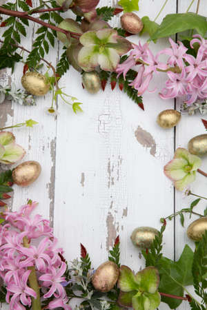 Flowers and eggs full floral frame over rustic wooden boardsの写真素材
