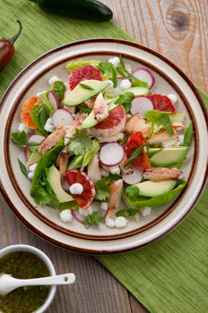 Fusion of Mexican cuisine and a traditional seafood crab salad. Closeup of Blood Orange Crab Posole Salad with fresh cooked Dungeness crab meat, avocado, radish, Romaine lettuce, and white hominy.の写真素材