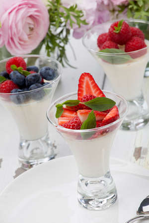 Closeup of Vanilla Panna Cotta Dessert garnished with fresh strawberry, blueberry, and raspberryの写真素材
