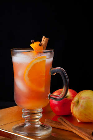 Close up of Spicy Apple Cider on a tray with mini pumpkins, fresh apples, and cinnamon sticksの写真素材