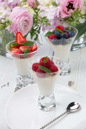 Closeup of Vanilla Panna Cotta Dessert garnished with fresh strawberry, blueberry, and raspberryの写真素材