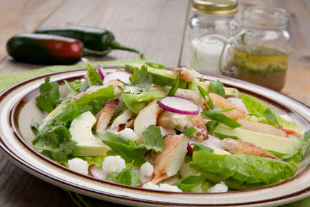 Fusion of Mexican cuisine and a traditional seafood crab salad. Closeup of Crab Posole Salad with fresh cooked Dungeness crab meat, avocado, radish, Romaine lettuce, and white hominy.の写真素材