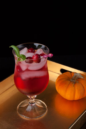 Closeup of Whiskey-Cranberry cocktail on a tray with mini pumpkins. Fall Drinks series.