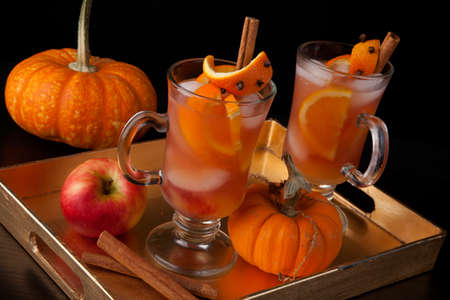Closeup of Spicy Apple Cider on a tray with mini pumpkins, fresh apples, and cinnamon sticks. Fall Drinks series.の写真素材