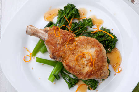 Closeup of sesame-crumbed pork chops with asian greens.の写真素材