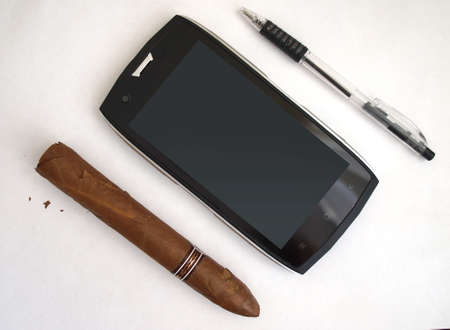 cigar, smartphone and pen on a white backgroundの写真素材