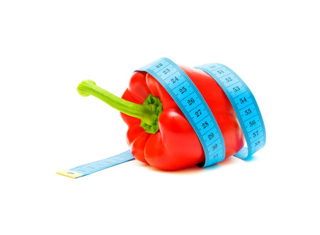 red pepper and a measuring tape on white background close-upの写真素材