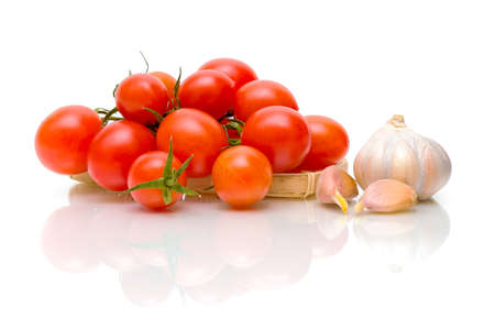 ripe tomatoes and garlic on a white background with reflection closeupの写真素材