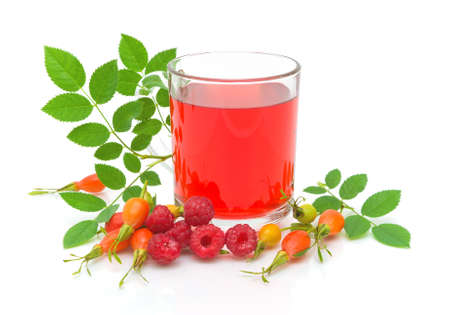 ripe raspberries, wild rose berries and a cup of tea isolated on white close-upの写真素材