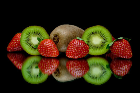 fresh juicy strawberries and kiwi on a black background with reflection closeupの写真素材