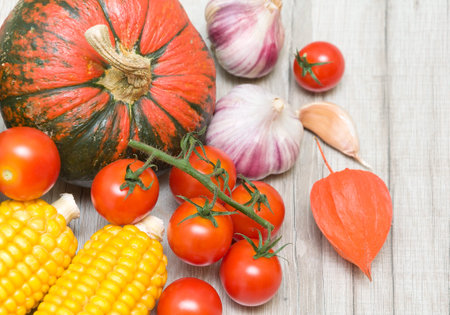 cherry tomatoes, ripe pumpkin, corn, garlic and cape gooseberries close-up. horizontal photo.