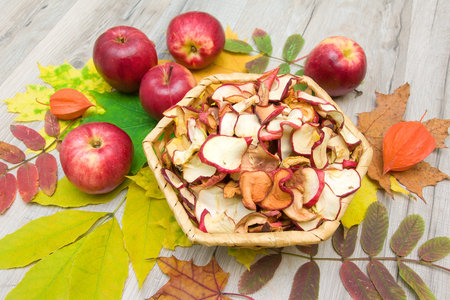 fresh and dried apples on autumn leaves. top view - horizontal photo.