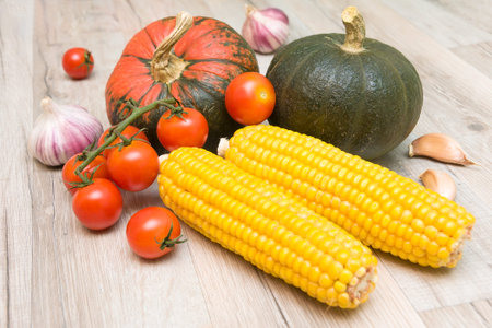 healthy food. Fresh vegetables: pumpkin, corn, cherry tomatoes and garlic on a wooden board...