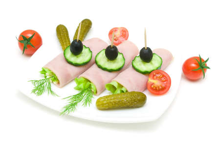 tasty rolls of ham with vegetables on the plate on a white . horizontal photo.の写真素材