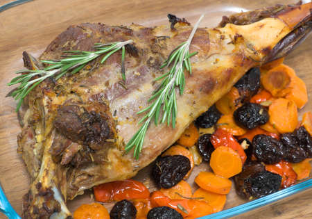 roasted leg of lamb with prunes, carrots and rosemary closeup. horizontal photo.の写真素材