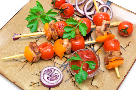 skewers of meat with vegetables on a plate on a white background. horizontal photo.の写真素材