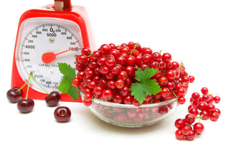 ripe red currants, kitchen scales and cherries on a white background close-up. horizontal photo.の写真素材