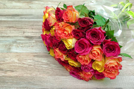 bouquet of fresh roses on a wooden background close-up. horizontal photo.の写真素材