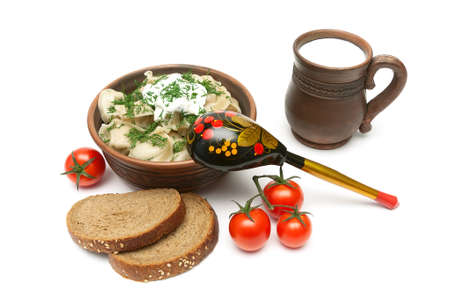 Russian dumplings with meat in an earthenware bowl, bread, milk and tomatoes on a white backgroundの写真素材